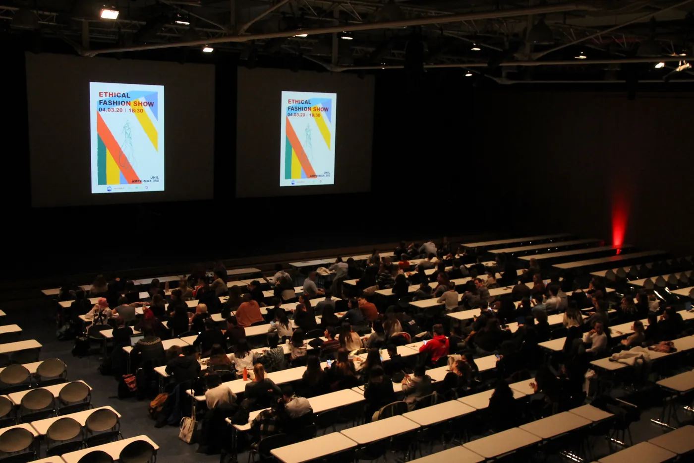 L'Amphimax 350 se remplit avant le défilé. Sur les deux écrans, l'affiche : Ethical Fashion Show, 04.03.20, 18:30