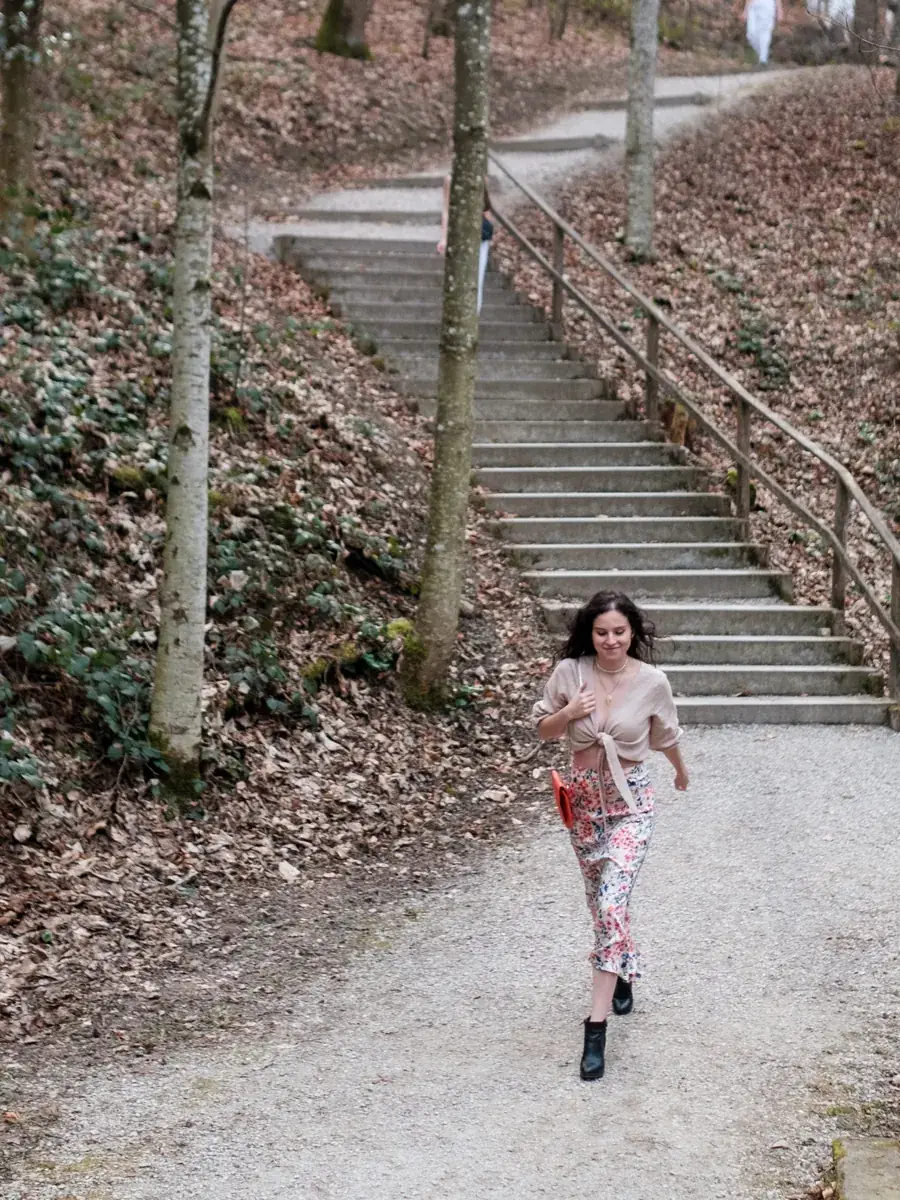 Une mannequin descend un chemin de forêt au pied d'un escalier