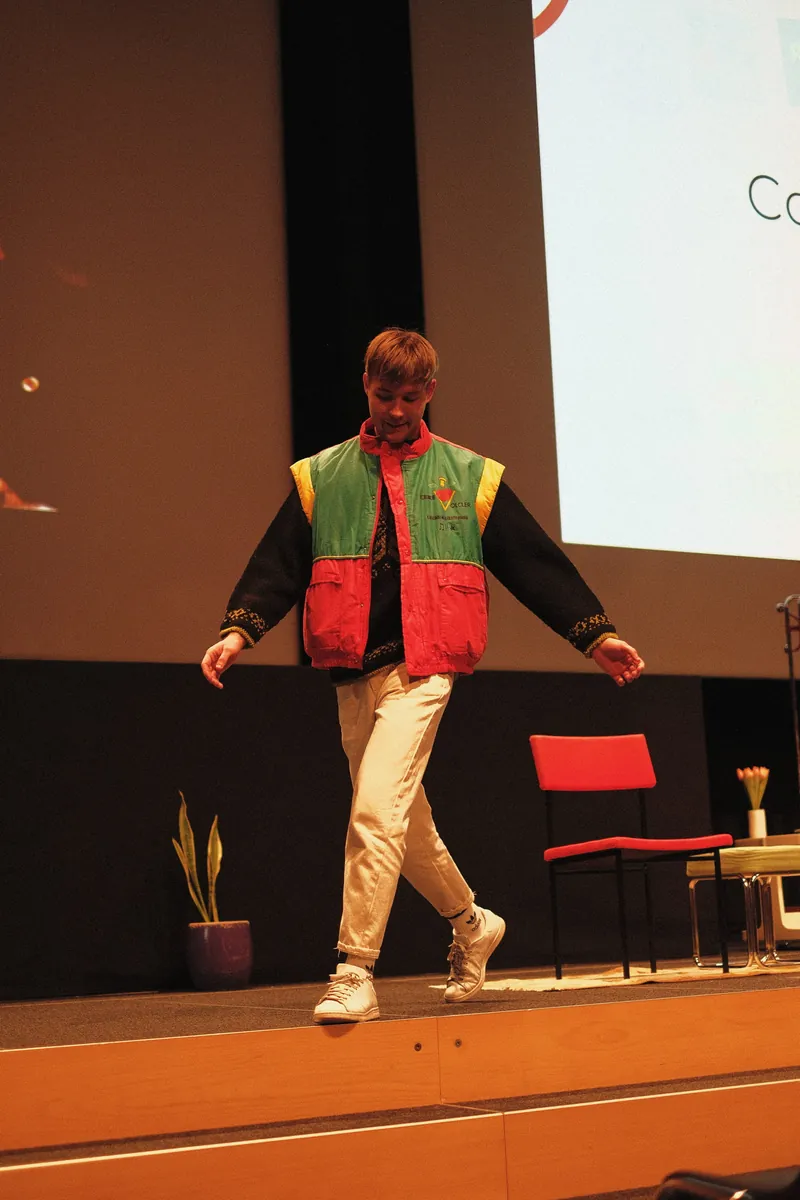 Un mannequin en veste rouge, verte et jaune sur la scène de l'édition 2022